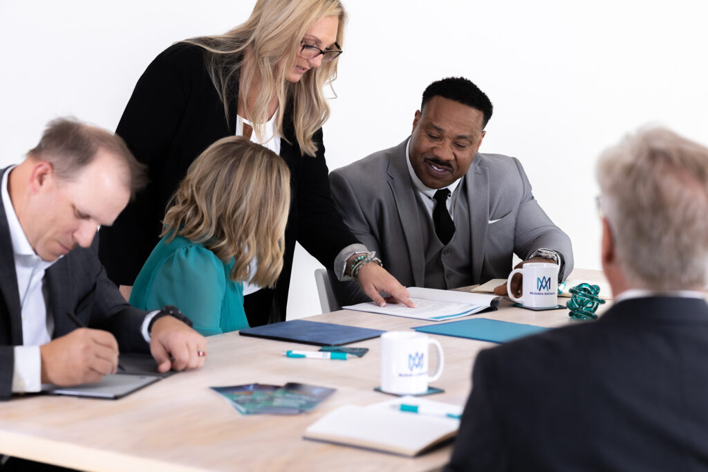 A McEntire Advisory expert leads a team discussion at a conference table, reviewing reports for business litigation and forensic accounting support.