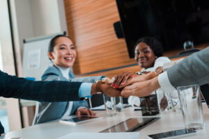 Business team stacks hands in agreement, symbolizing successful financial dispute resolution through collaboration and professional support.