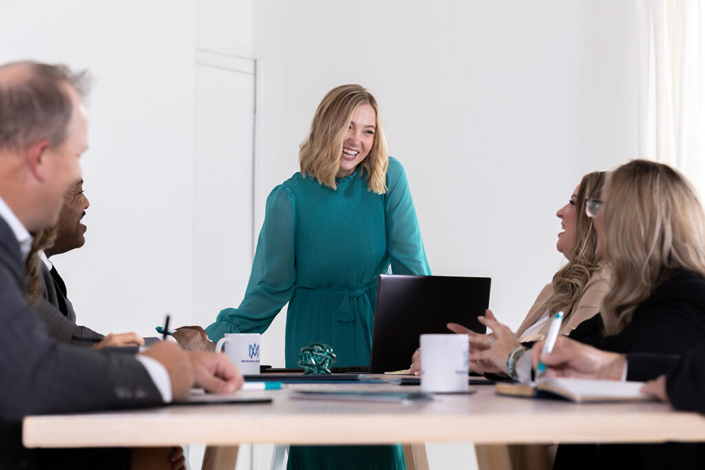 A professional woman leads a collaborative business meeting, representing the role of a qualified appraiser in successful transactions.

