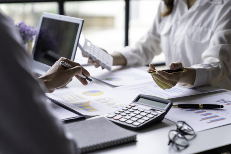 A forensic accountant reviewing financial documents and calculations during a business investigation.